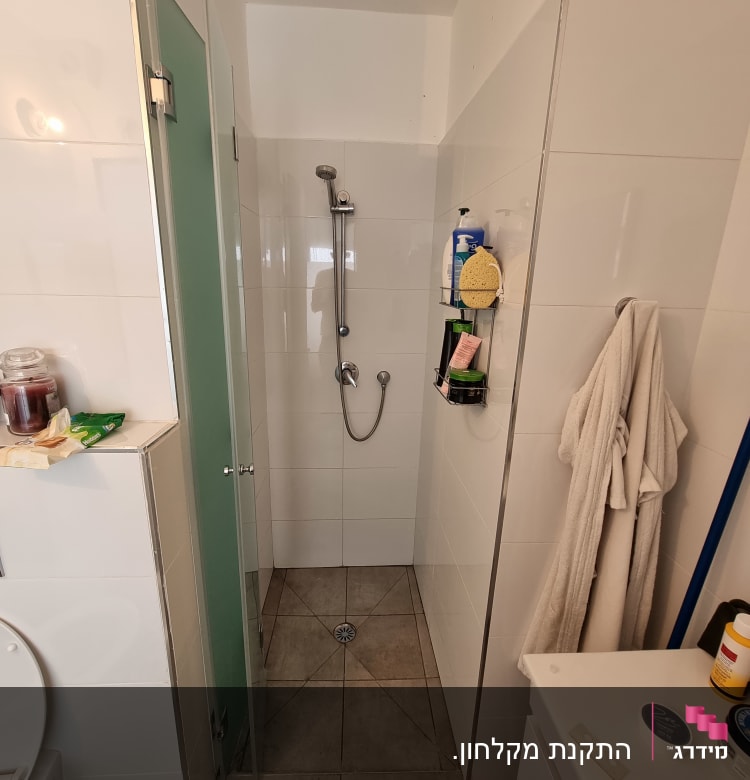 מקלחת עם ראש מקלחת, מדף עם מוצרים וספוג